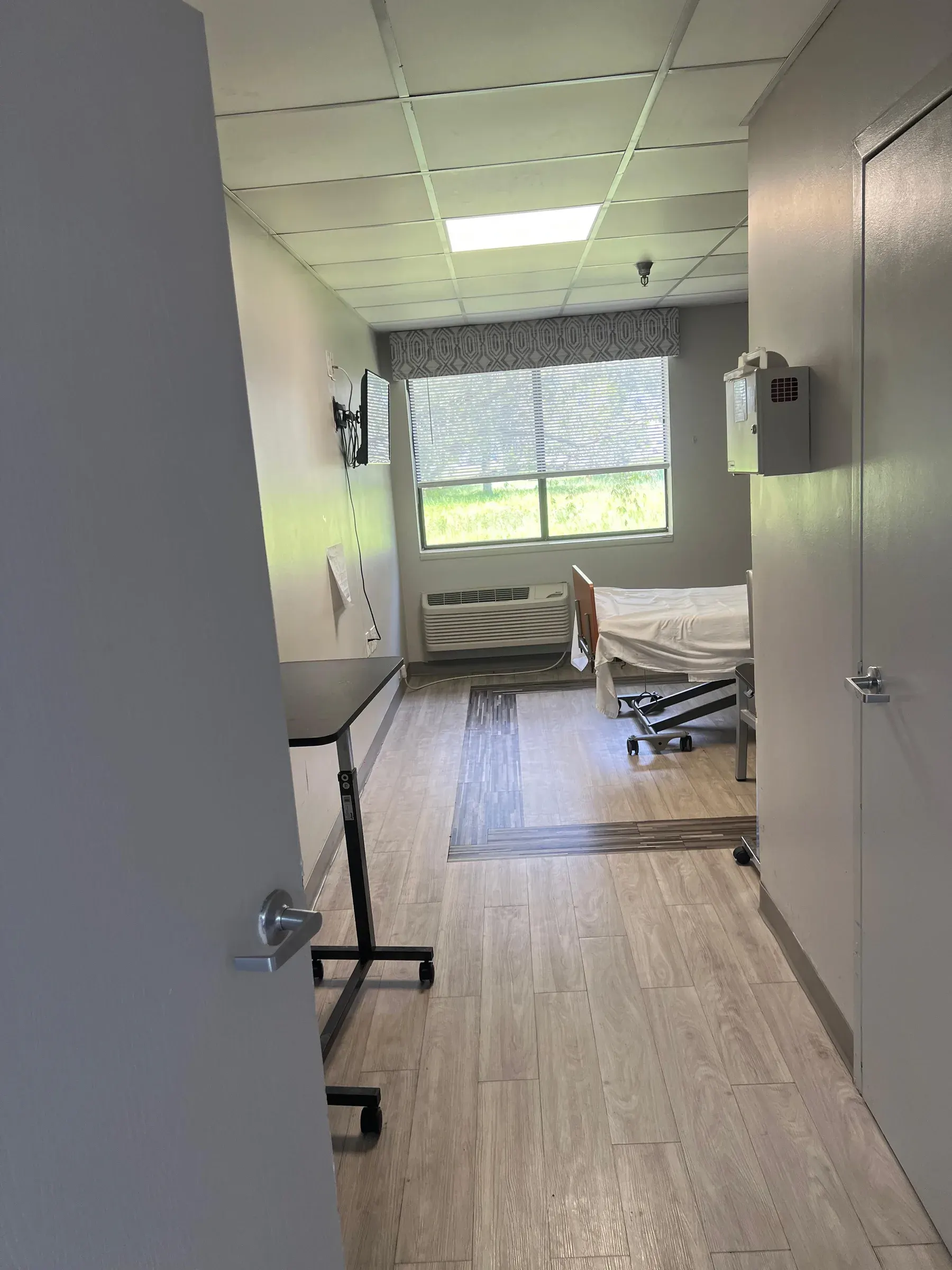 A resident room at Vivo Healthcare Gateway, bed made and the blinds open